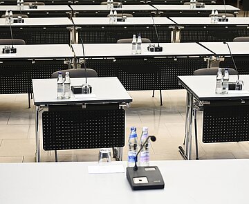 Einzelne Tische mit Mikrofonen im Bürgersaal