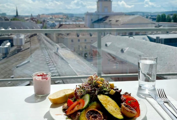 Voller Teller mit Essen auf einem Tisch auf einer Dachterasse.