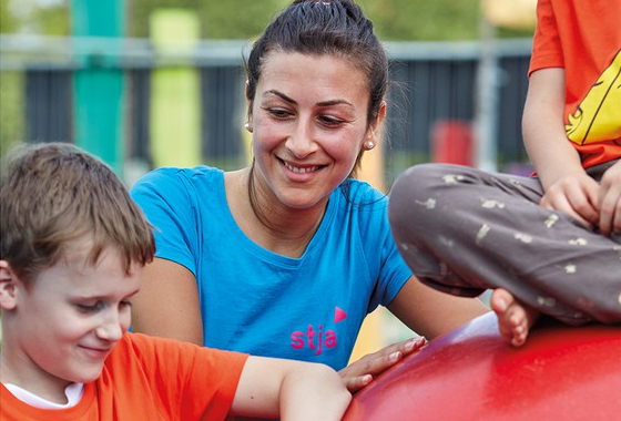 Junge Frau mit Kind auf einem Spielplatz