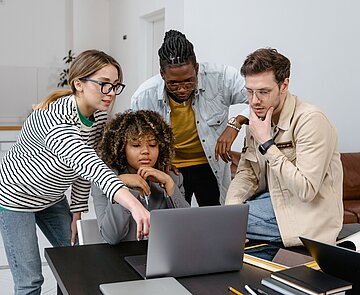 Junge Menschen schauen auf einen Laptop
