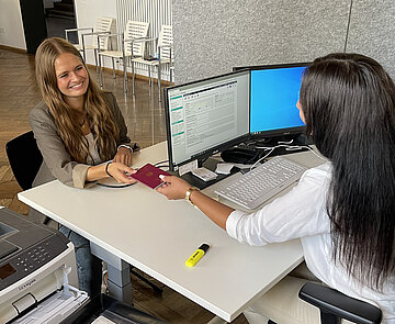 Junge Dame bekommt neuen Reisepass im Bürgerbüro