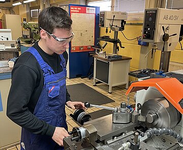 Junger Mann an der Drehmaschine