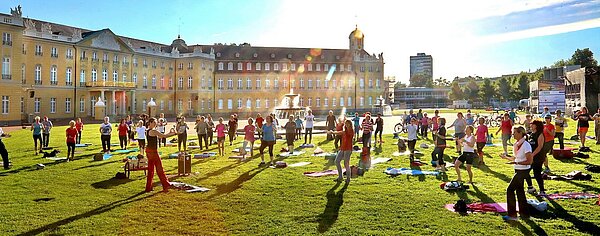 Menschen beim Sport auf der Wiese vor dem Karlsruhe Schloss