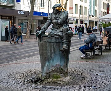 Der Herrenbrunnen mit seiner Steinfigur  in der Fußgängerzone der Kaiserstraße