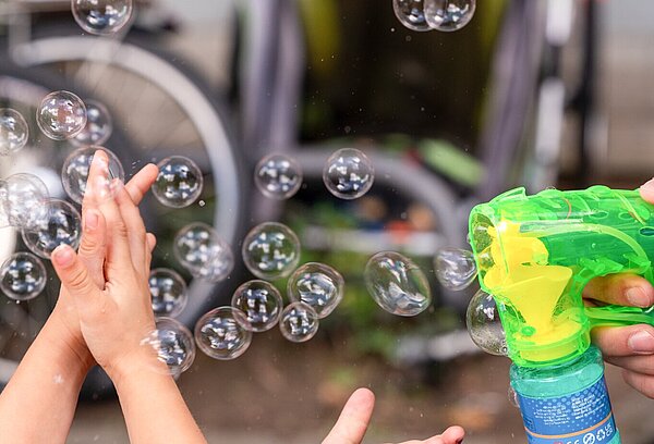 Kinder spielen mit Seifenblasen