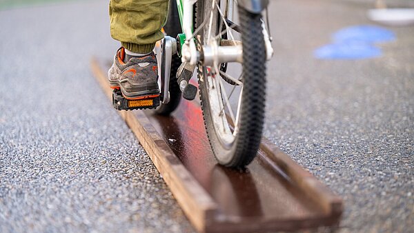 Kind fährt mit Fahrrad einen Fahrradparcour