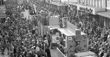 Umzugswagen des ASV Wolfartsweier in der Pfinztalstraße. Am Straßenrand Menschenmenge. 