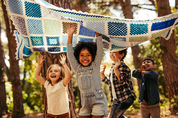 Kinder haben Spaß zusammen im Wald.