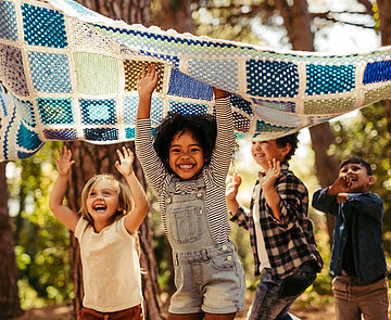 Kinder haben Spaß zusammen im Wald.