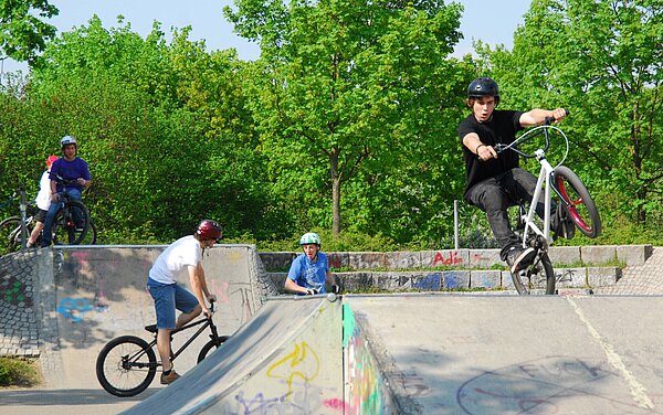 Das Bild zeigt Jugendliche mit ihren Fahrrädern auf dem Parcour des Skateplatzes in der Günther-Klotz-Anlage.