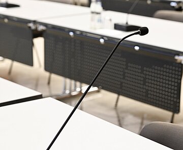 Einzelne Tische mit Mikrofonen im Bürgersaal