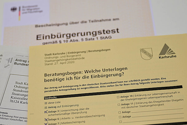 Das Bild zeigt mehrere Dokumente, die für eine Einbürgerung benötigt werden.