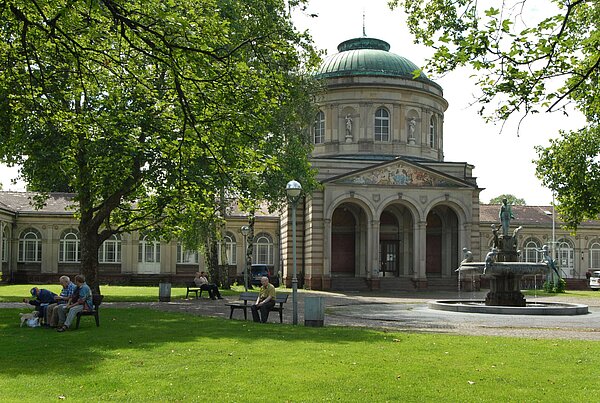 Das Bild zeigt das Vierordtbad und den Hygieia-Brunnen am Festplatz.