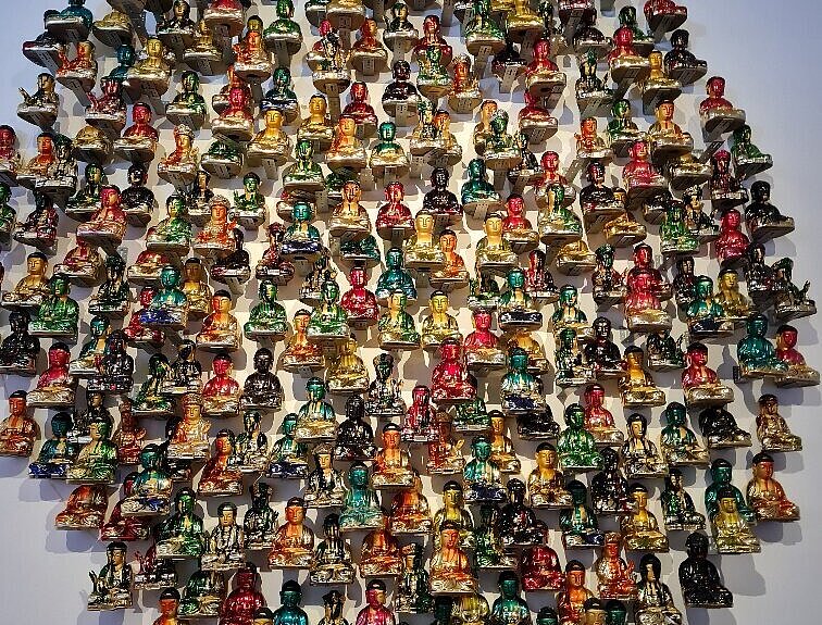 Kunstwerk mit bunten Buddha-Figuren aus Glas