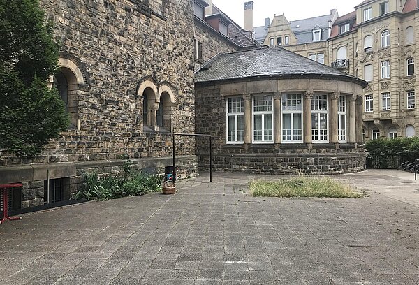 Kirchplatz mit Gehwegplatten, Kirche, Anbau Häuser im Hintergrund