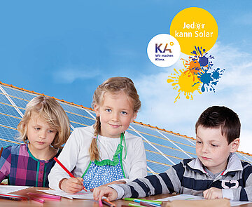Auf diesem Symbolbild sehen Sie drei malende Kinder vor der Photovoltaikanlage eines Hausdaches.