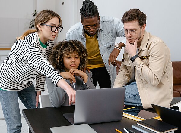 Junge Menschen schauen auf einen Laptop
