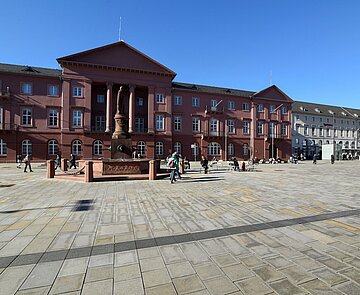 belebter Marktplatz mit Menschen  und Blick auf das Rathaus