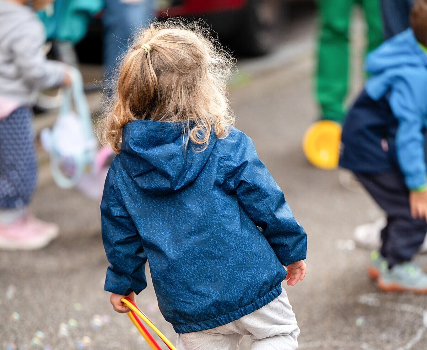 Kind spielt auf Straße mit Ring