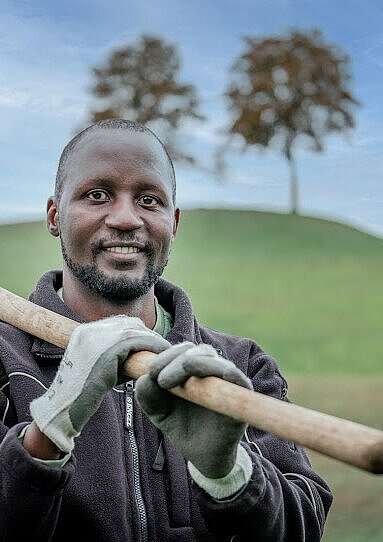 Junger Mann mit Schaufel über der Schulter