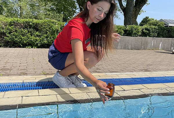 Junge Frau entnimmt Wasserprobe