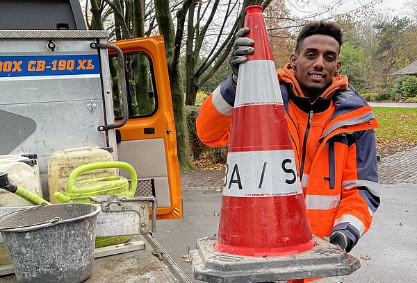 Junger Mann mit einem Leitkegel