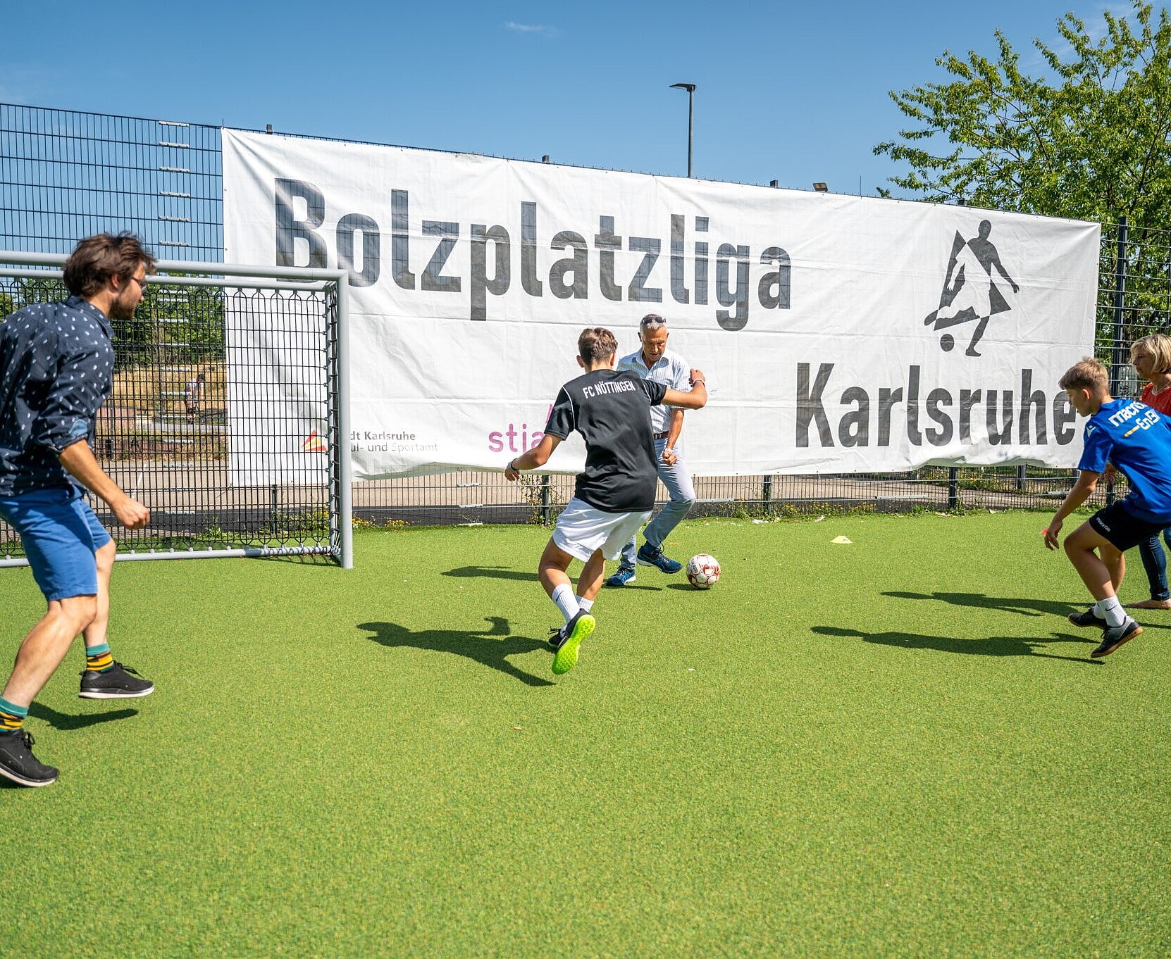 Bürgermeister Martin Lenz und Stadtrat Aljoscha Löffler spielen gegen die Kinder der Bolzplatzliga.
