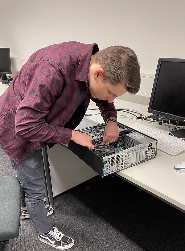 Junger Mann baut an einem PC