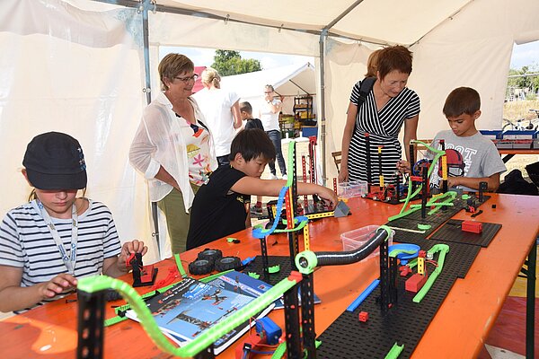 Beim Feriencamp können Kinder experimentieren, malen, musizieren und sich austoben. Hier bauen die Kinder mit Fischertechnik.