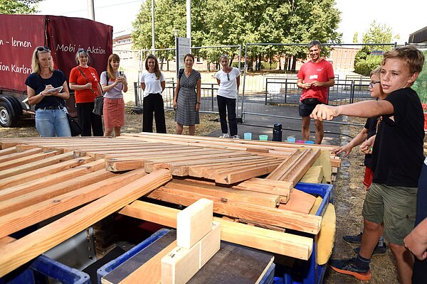 Beim Feriencamp können Kinder experimentieren, malen, musizieren und sich austoben. Hier haben einige Jungen eine Murmelbahnhütte gebaut.
