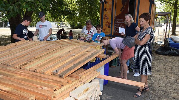 Beim Feriencamp können Kinder experimentieren, malen, musizieren und sich austoben.  Hier haben einige Jungen eine Murmelbahnhütte gebaut.