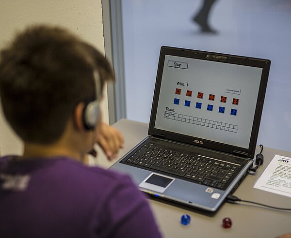 Ein Junge sitzt an einem Laptop