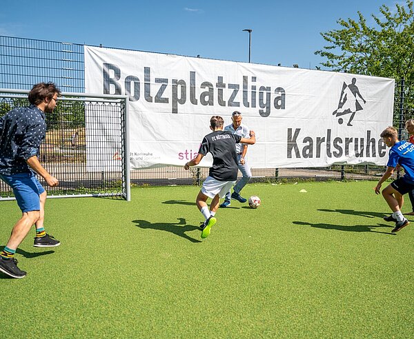 Bürgermeister Martin Lenz und Stadtrat Aljoscha Löffler spielen gegen die Kinder der Bolzplatzliga.