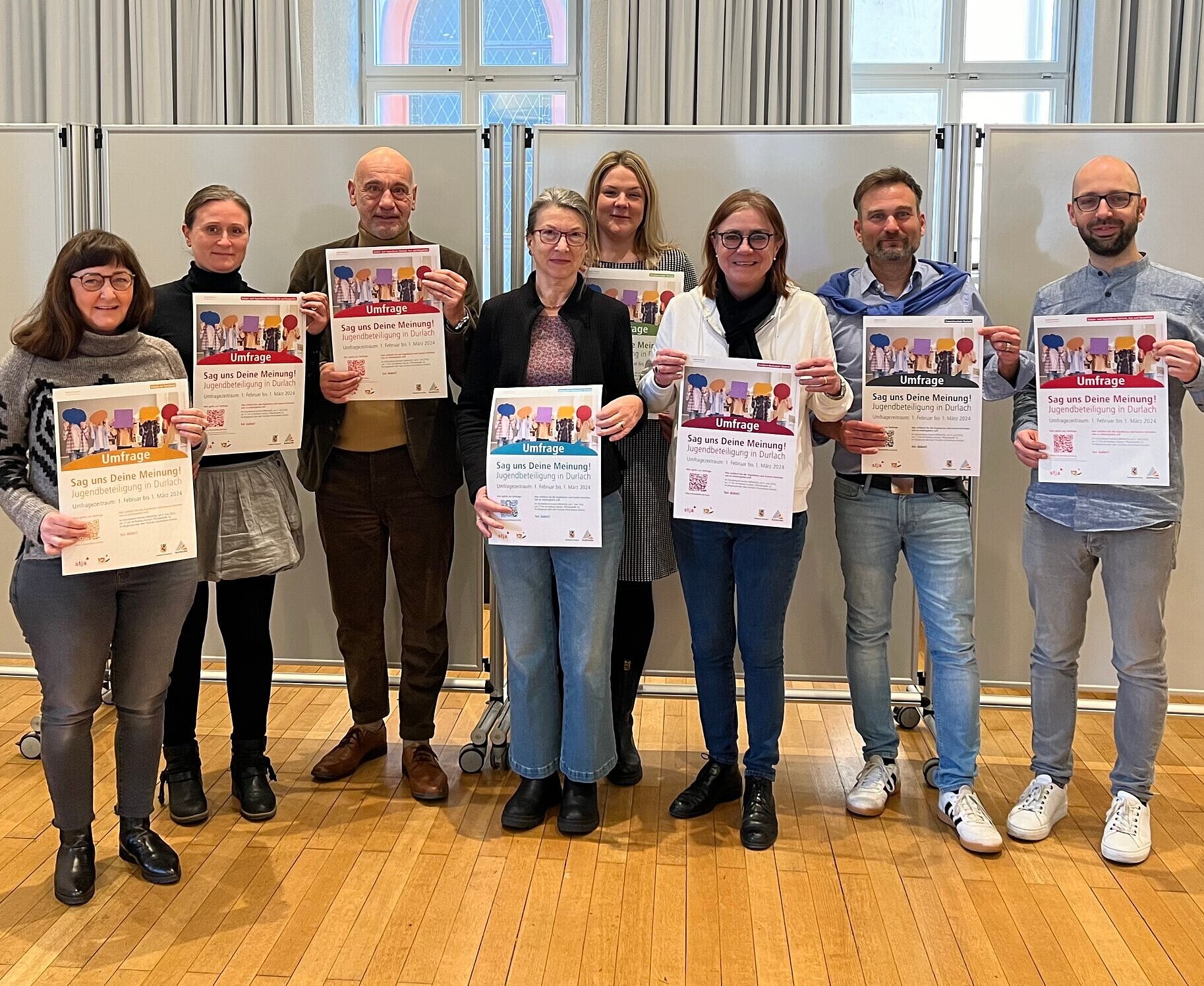 Mitglieder des Durlacher Ortschaftsrats, der Orts- und Stadtverwaltung, des Stadtjugendausschusses sowie des Kinder- und Jugendhauses präsentieren die Plakate für die gemeinsam erarbeitete Umfrage. 