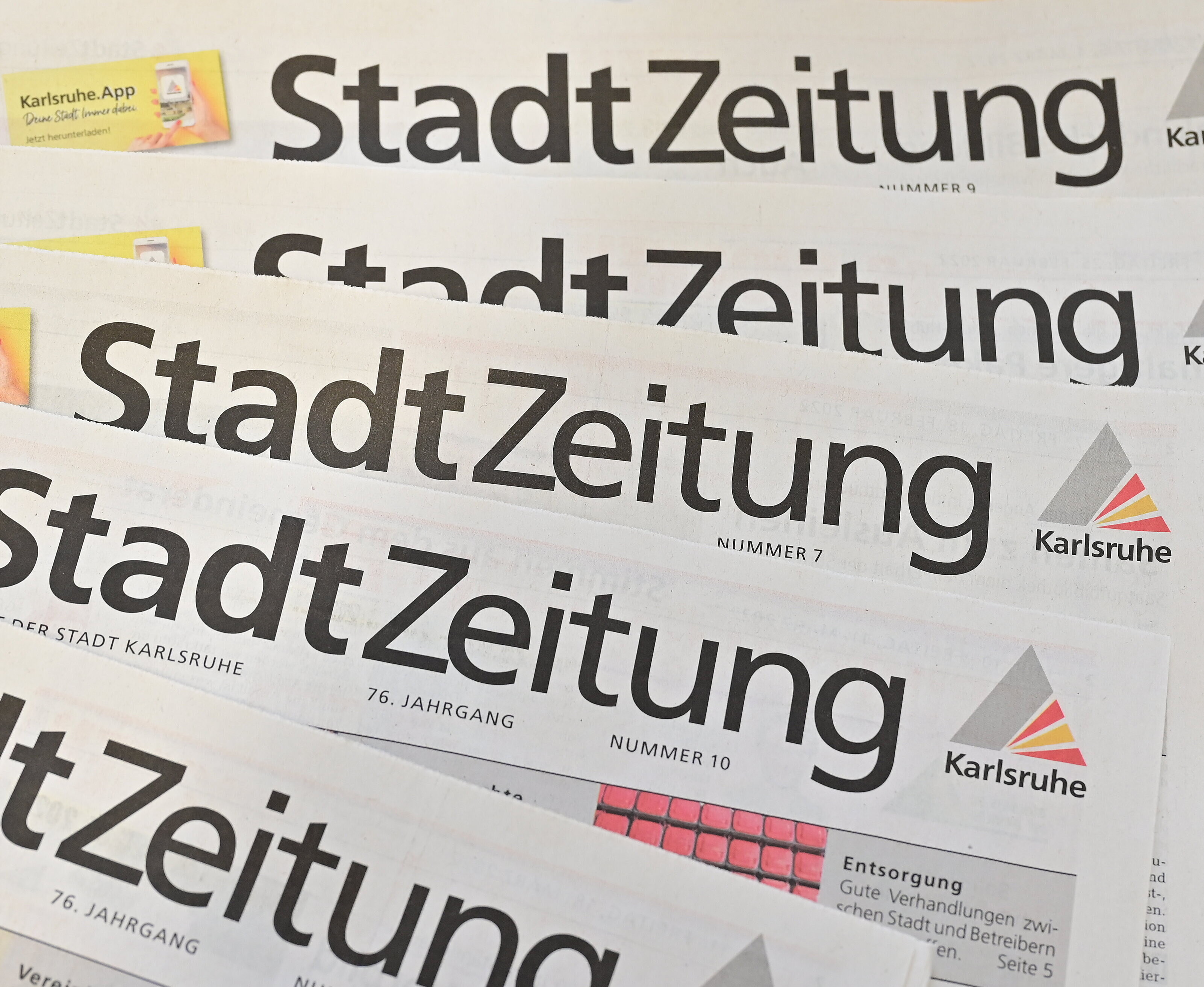 Ein aufgefächerter Stapel mit Stadtzeitungen