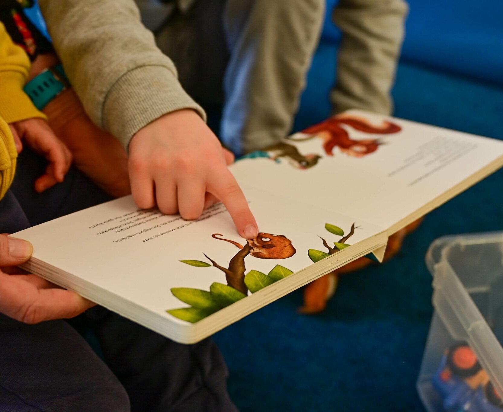 Zwei Kinder schauen ein Bilderbuch an.